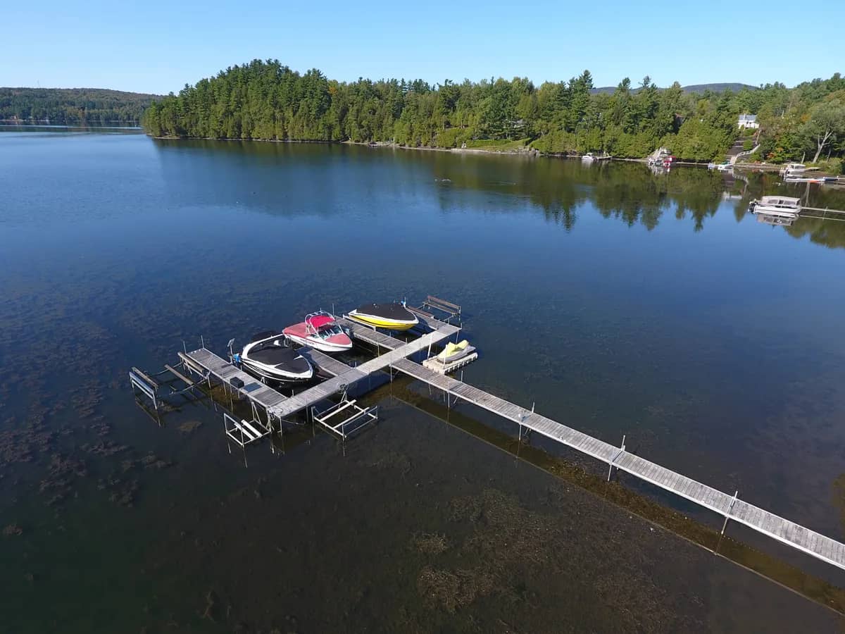 Vue aérienne d’un long quai avec élévateur à bateau sur un lac calme