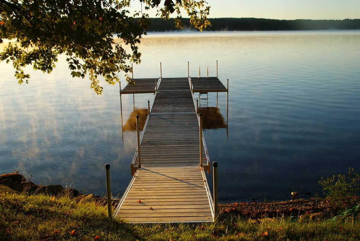 Quai de bois paisible s’avançant sur un lac au petit matin
